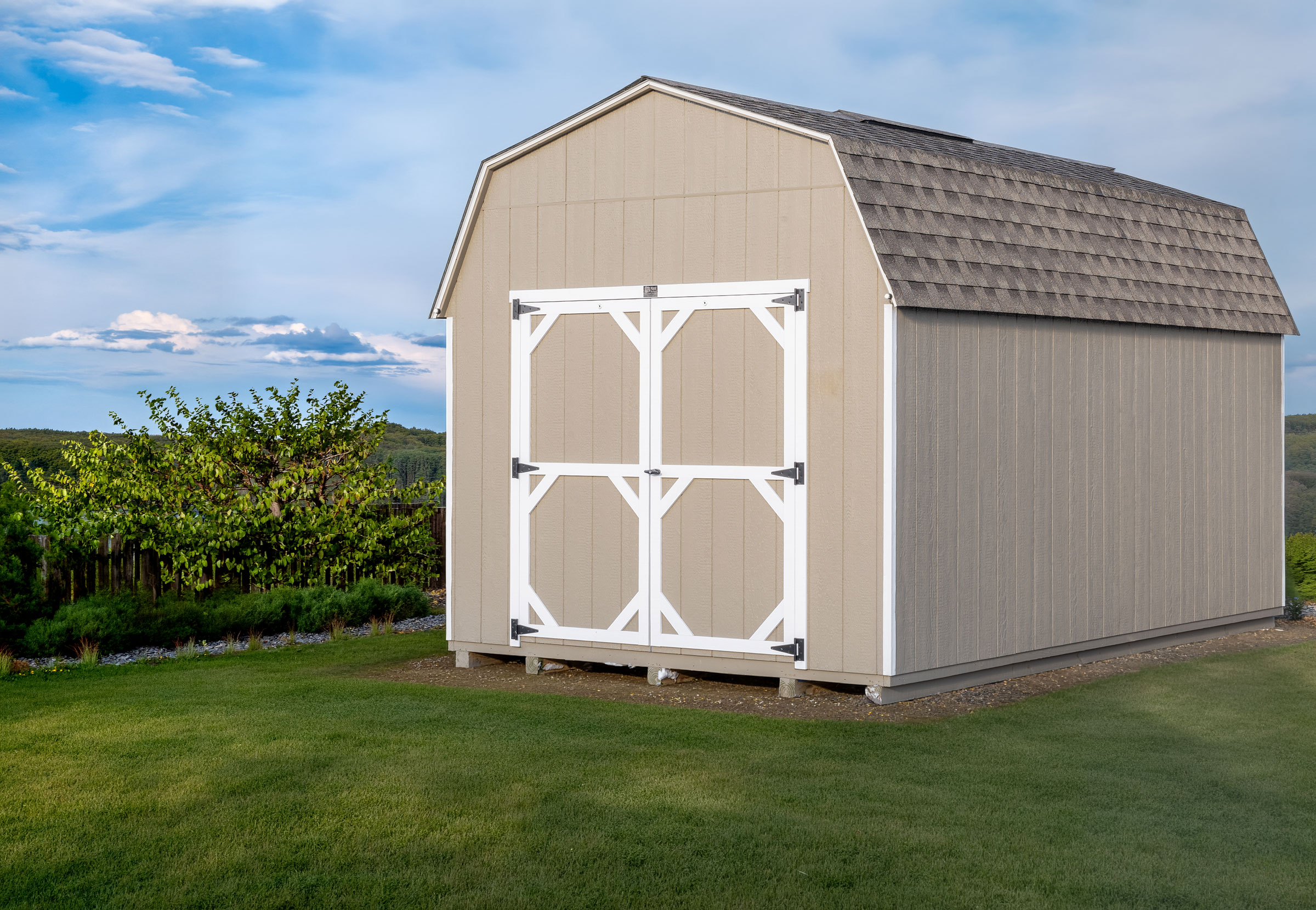 A 10x16 Mast Mini Barn 10ft Lofted Painted Pro shed shown with architectural shingles, Tan with White trim