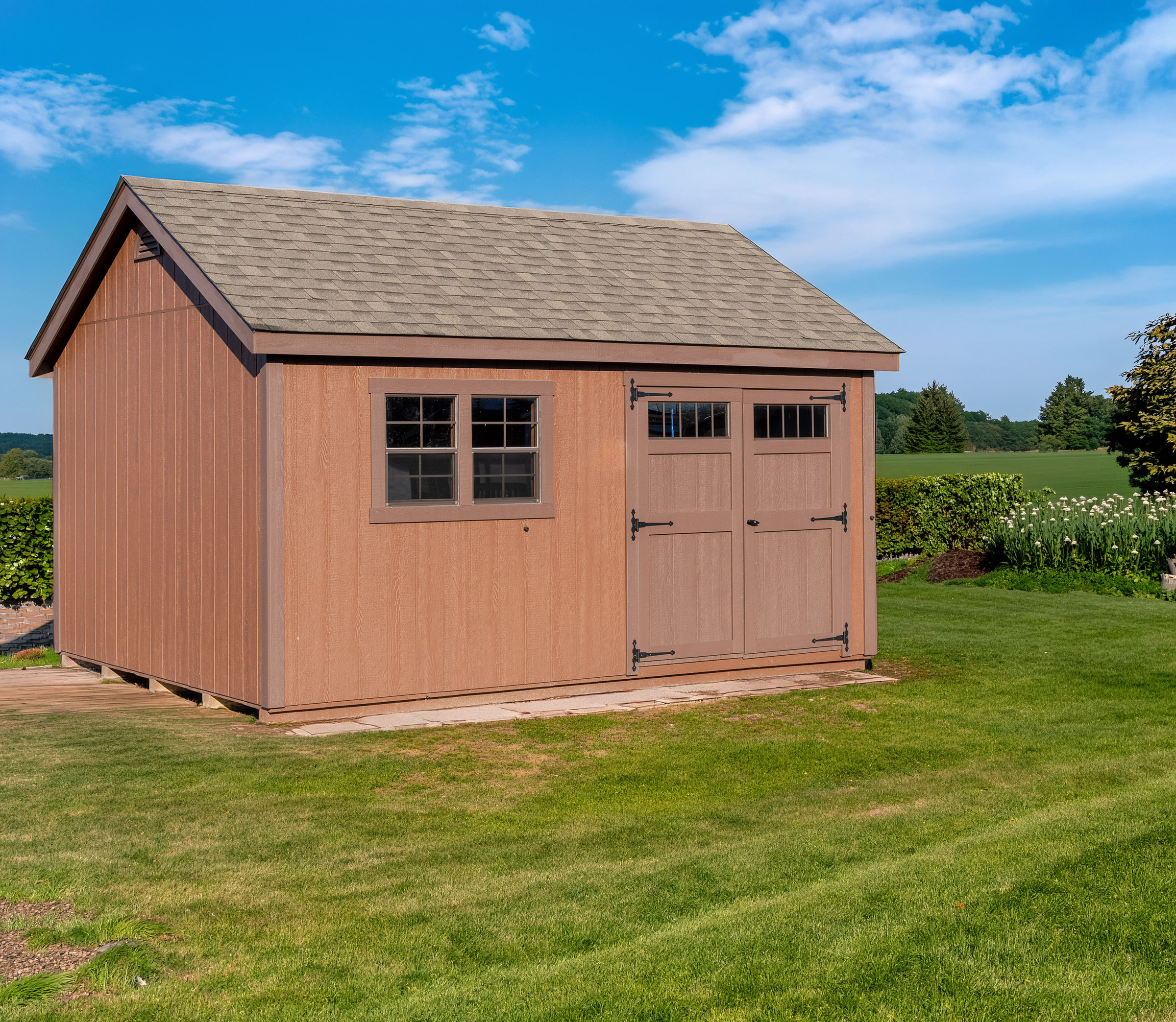 A 12x16 Mast Mini Barn Cape Cod shed shown in Chestnut Brown with Charcoal Brown trim, deluxe trim package