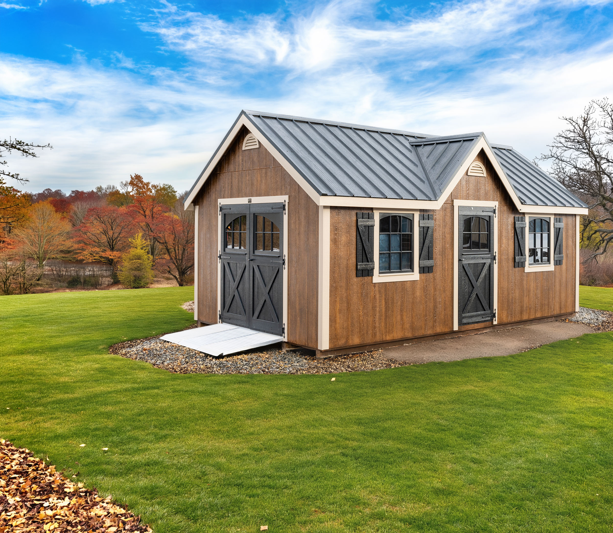 A 12x20 Mast Mini Barn Chalet shed shown in Chestnut Brown Urethane with Tuscan Clay trim, Black vintage doors and windows, deluxe trim package