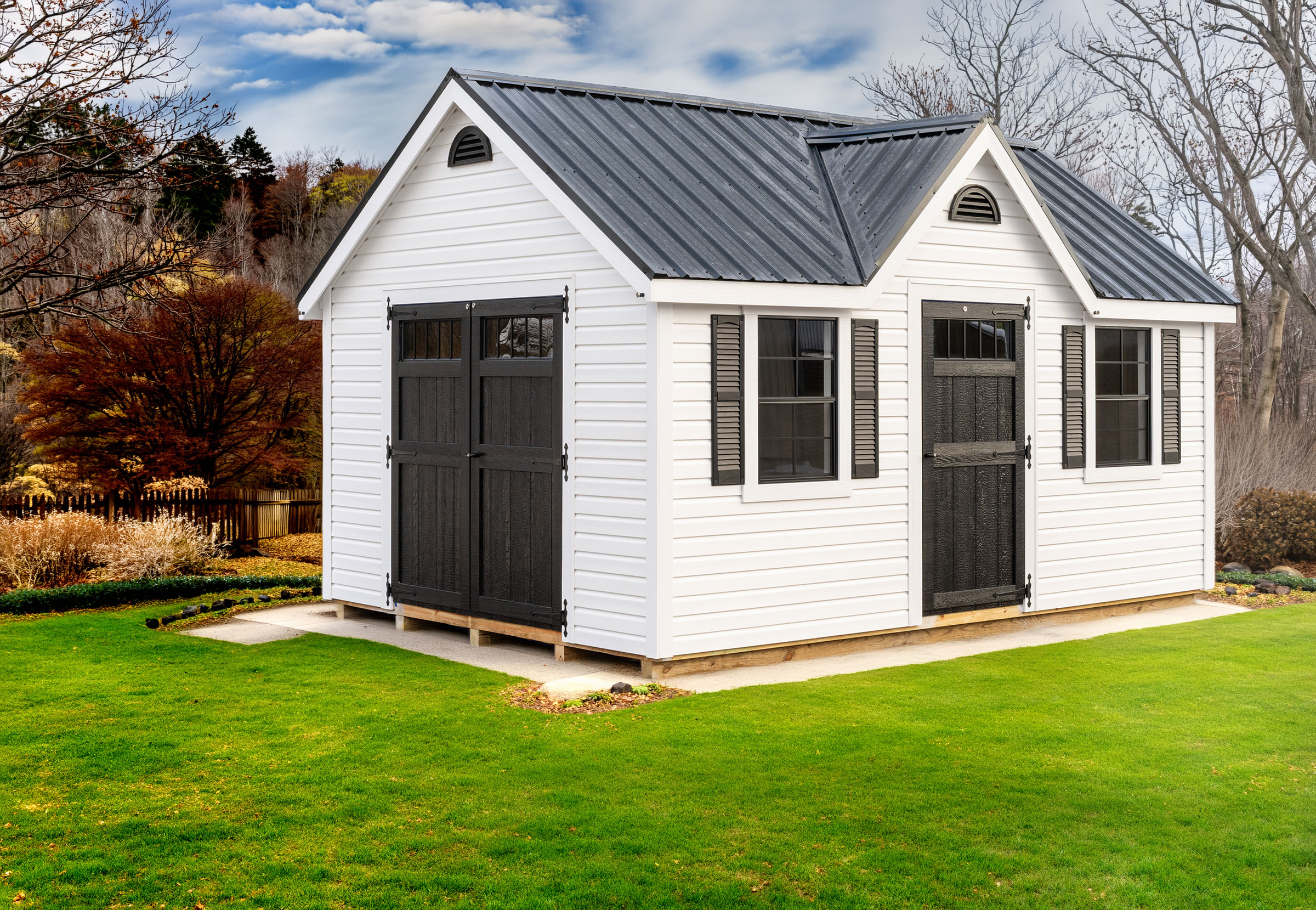 A 12x16 Mast Mini Barn Chalet shed shown in White Vinyl siding with White trim and Black doors