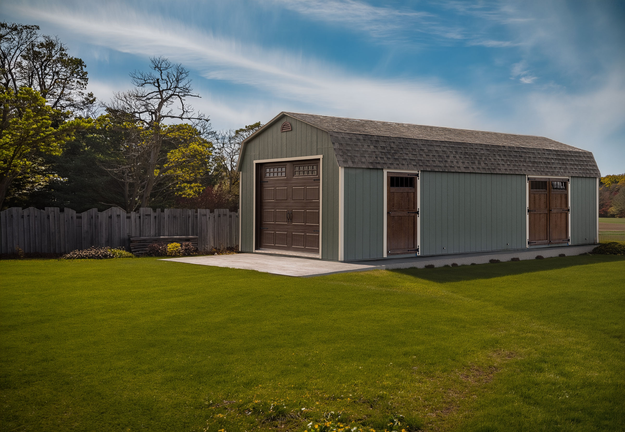 A 14x32 Mast Mini Barn Garage shown in Avocado Green with Elite Tan trim and Chestnut Brown Urethane doors
